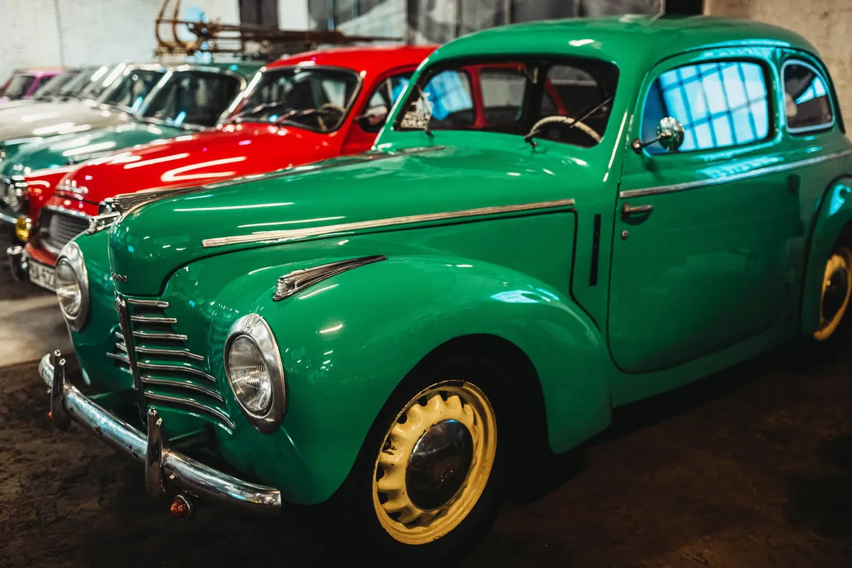 A row of restored classic cars parked together in a collection garage