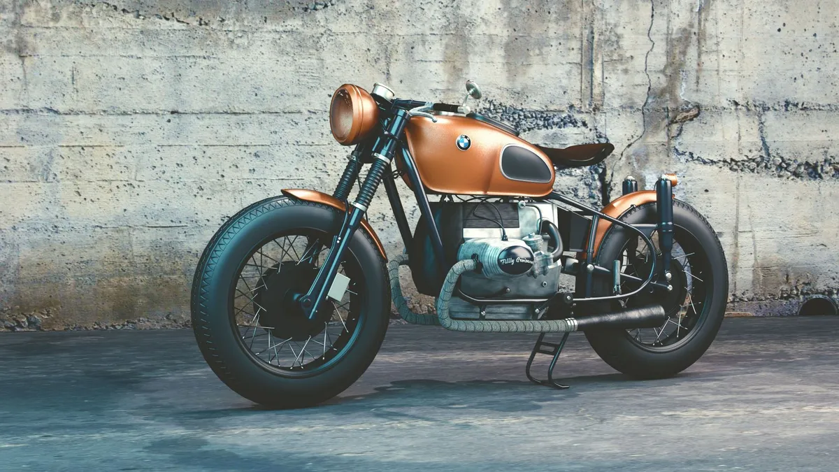 A restored vintage-styled motorcycle parked against a weathered concrete wall