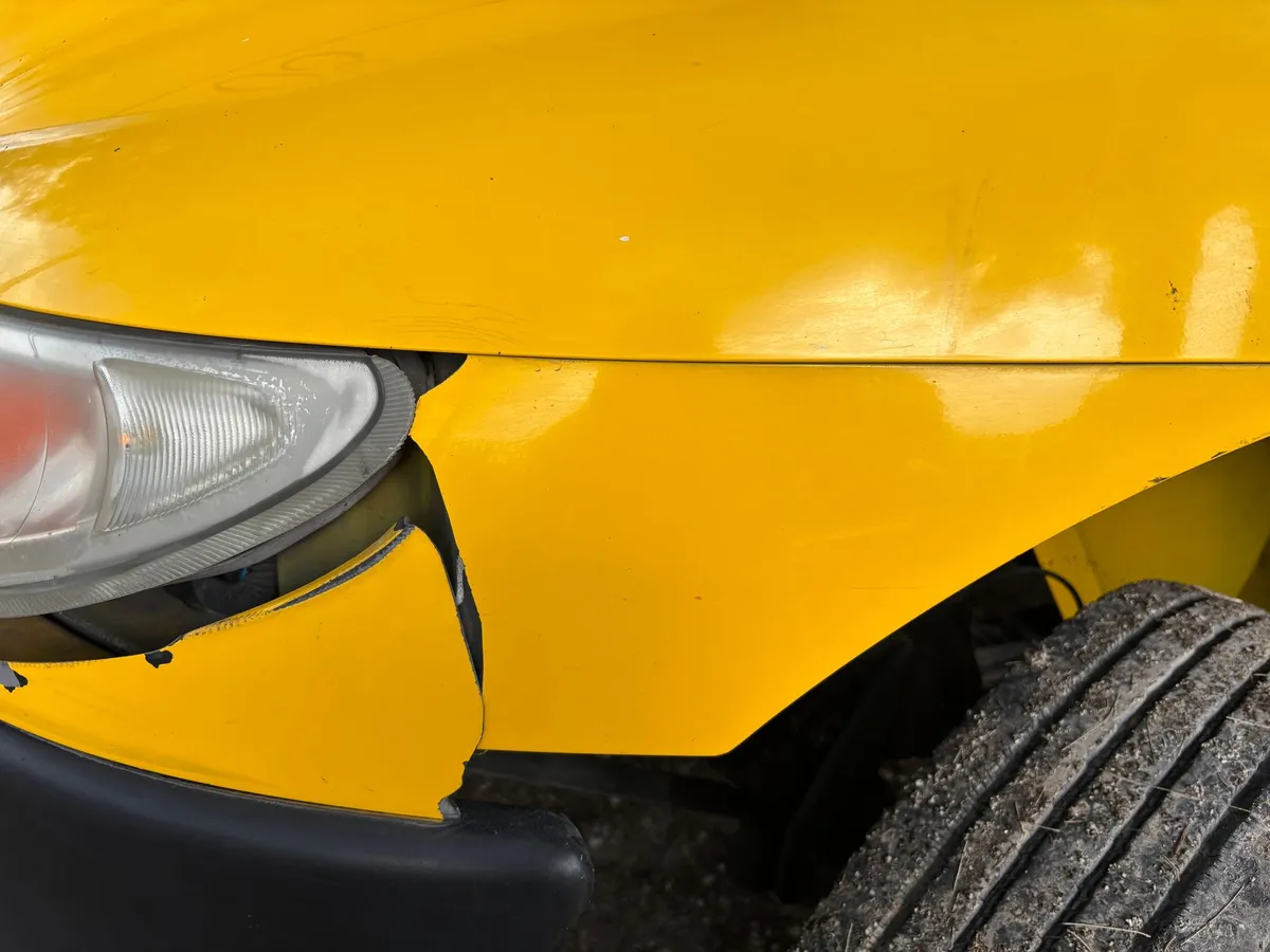 Close-up of a damaged front fender and headlight on a car after a collision