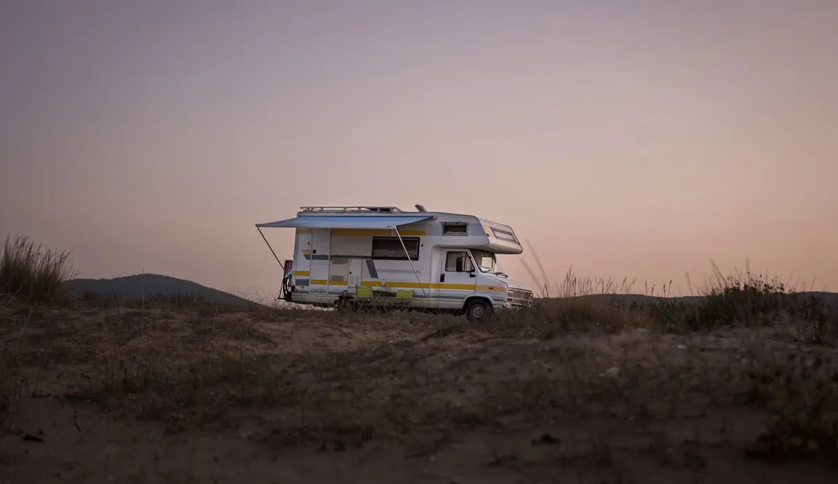 A motorhome parked in a scenic open landscape at dusk