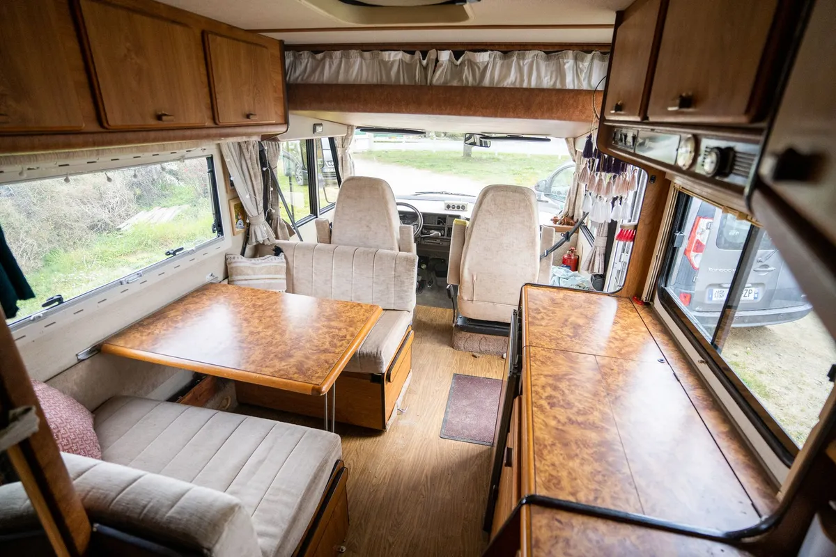 The interior living space of a motorhome, showing cabinetry and dining area
