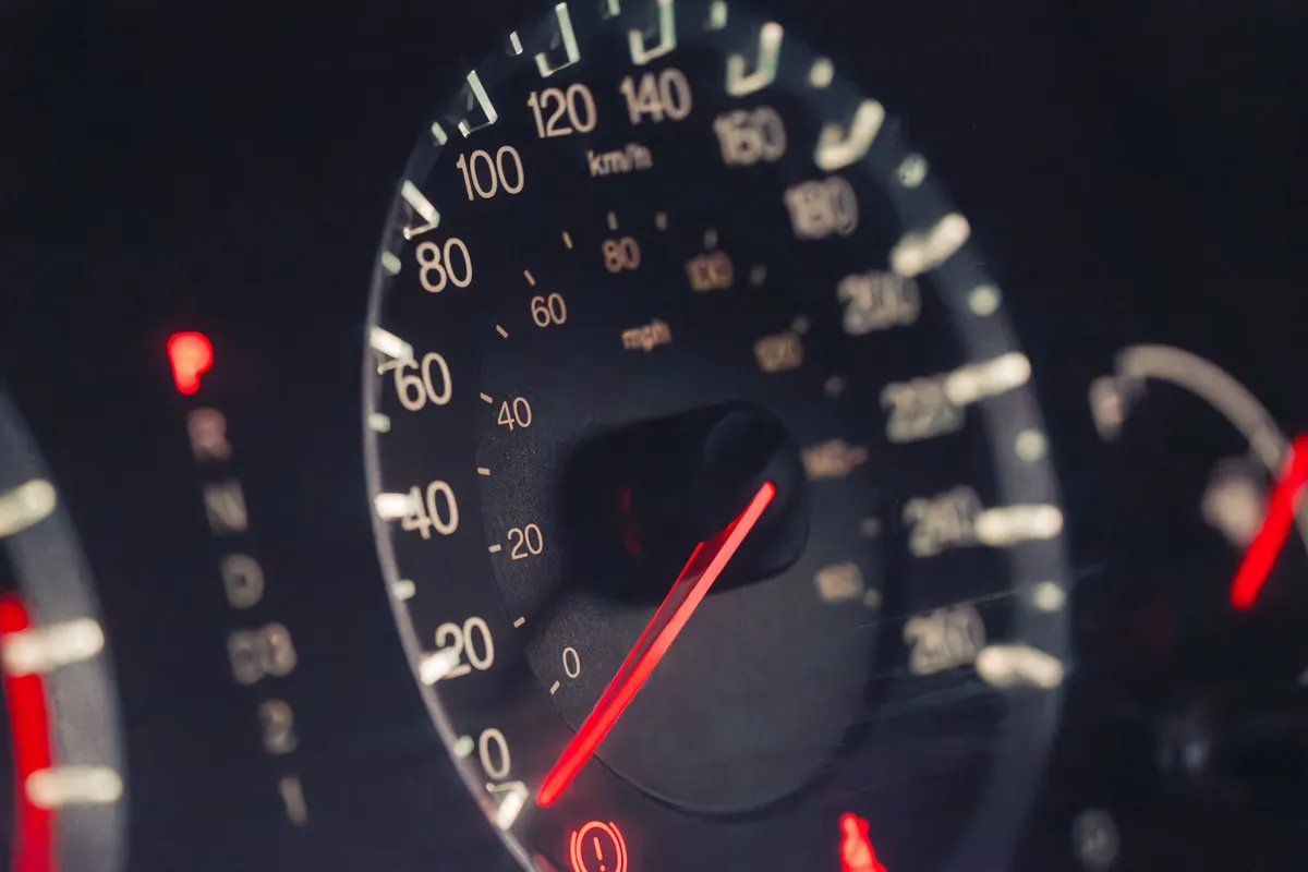 Close-up of a car's illuminated speedometer and dashboard